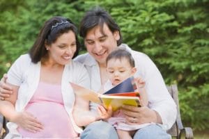 Hispanic mother and father reading to daughter